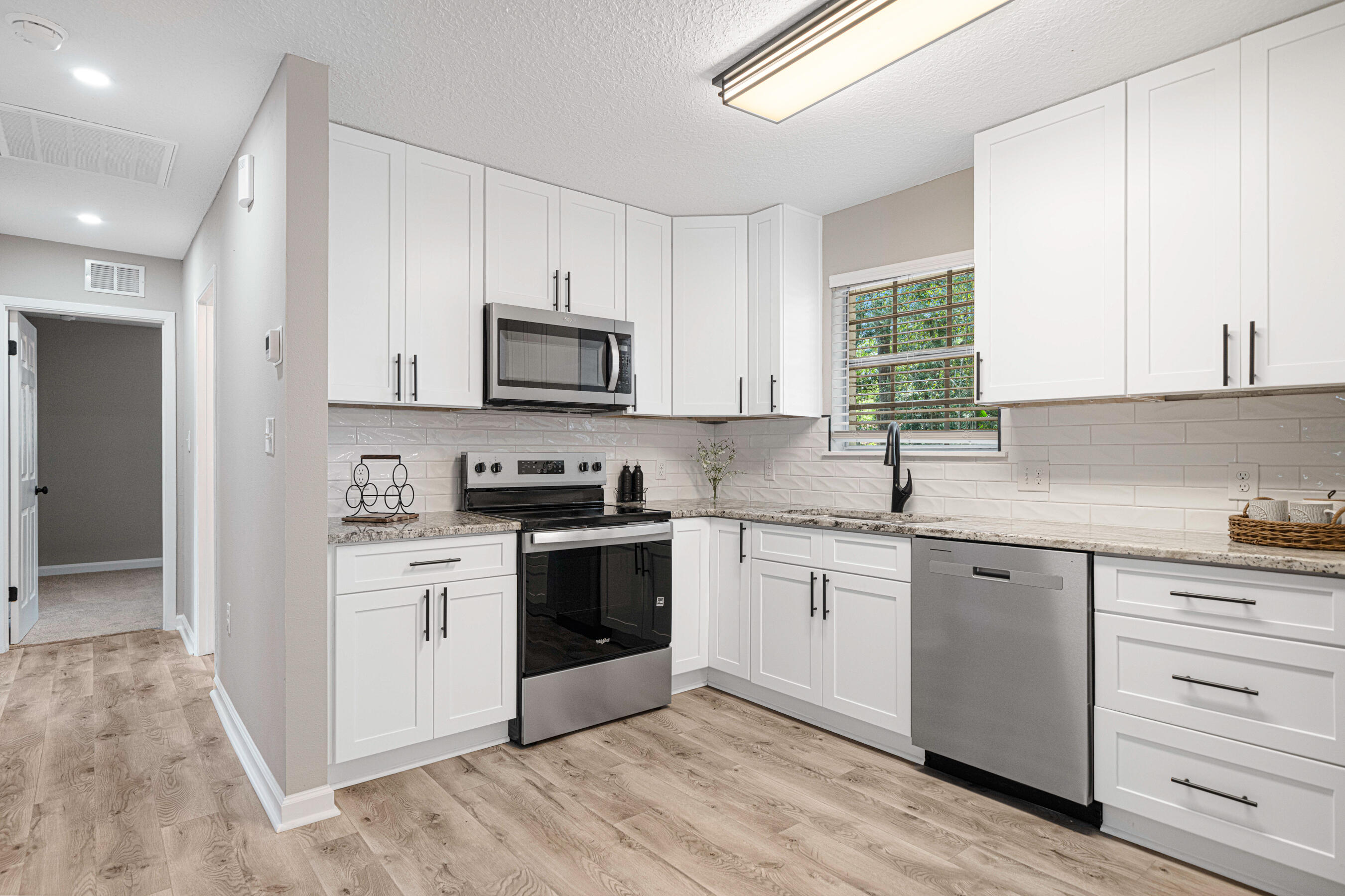 207 Oglesby Avenue Crestview, FL 32536 - Photo 7 of 30 a kitchen with stainless steel appliances granite countertop a stove a sink and a microwave