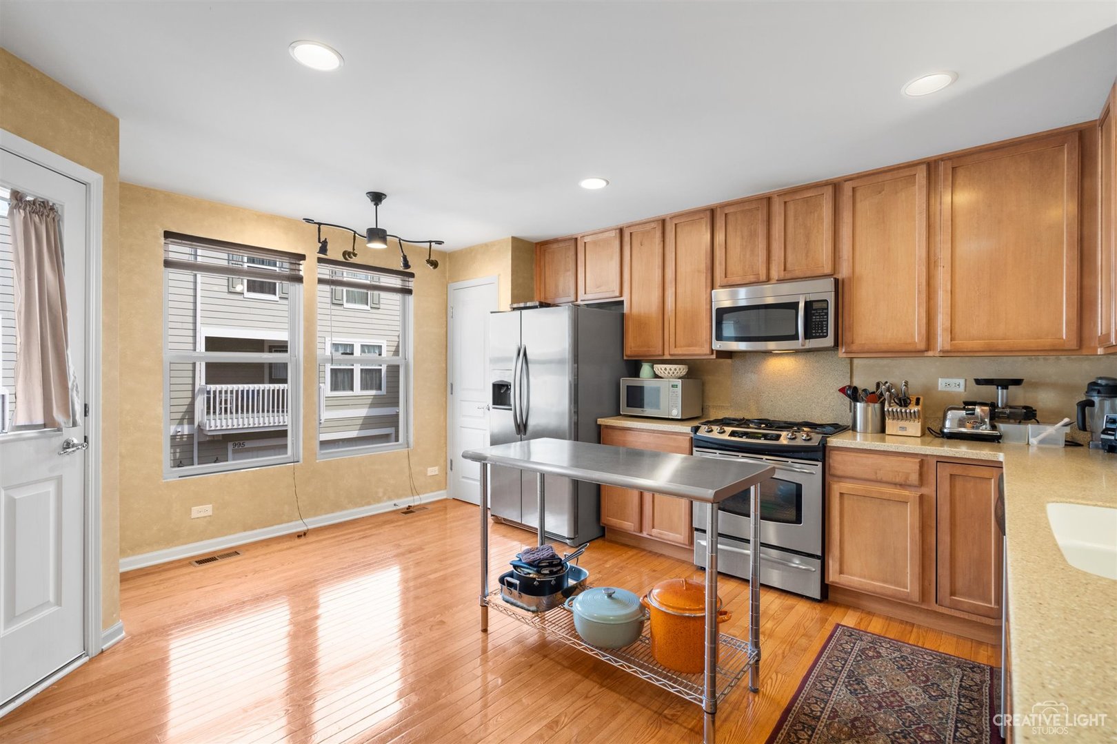 1005 Crane Point Elgin, IL 60124 - Photo 7 of 18 a kitchen with granite countertop a stove top oven a sink dishwasher a dining table and chairs with wooden floor