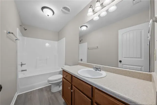 a bathroom with a sink a toilet a mirror and shower