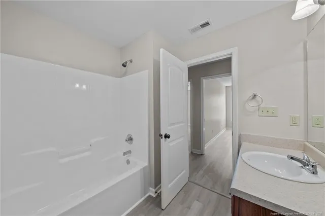 a bathroom with a tub sink double vanity and tub