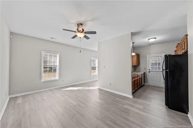 a view of a kitchen with a sink refrigerator and wooden floor