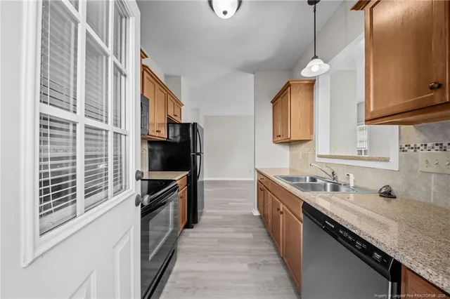 a kitchen with stainless steel appliances granite countertop a sink and a stove