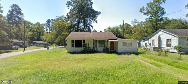 a front view of a house with yard and tree s