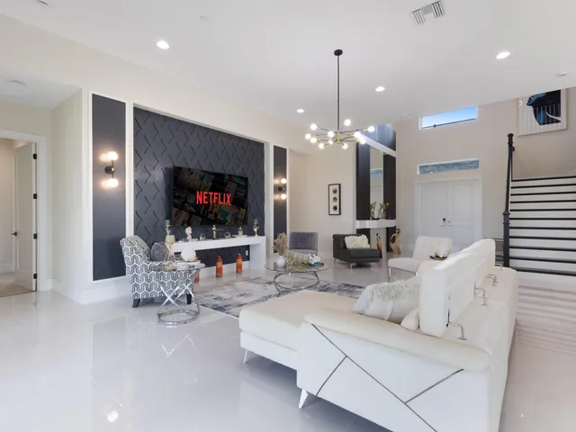 a living room with furniture a dining table and a chandelier