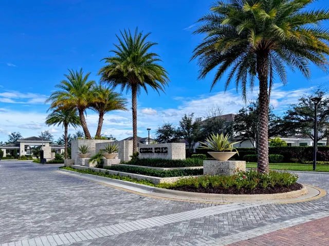 a palm tree sitting in front of a house with a garden
