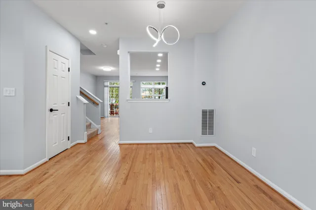 a view of a big room with wooden floor and windows