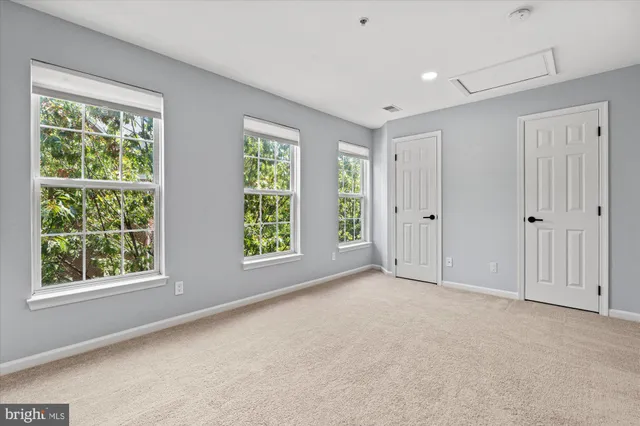 a view of an empty room with a window and a ceiling fan