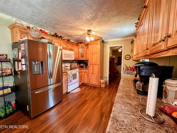 a kitchen with stainless steel appliances granite countertop a refrigerator stove and wooden floor