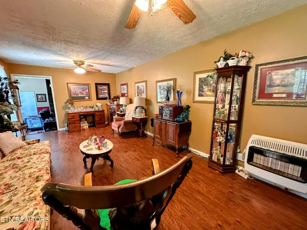 a living room with furniture a dining table and wooden floor