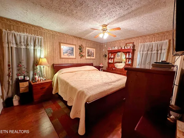 a bedroom with a bed and a large mirror on the dresser