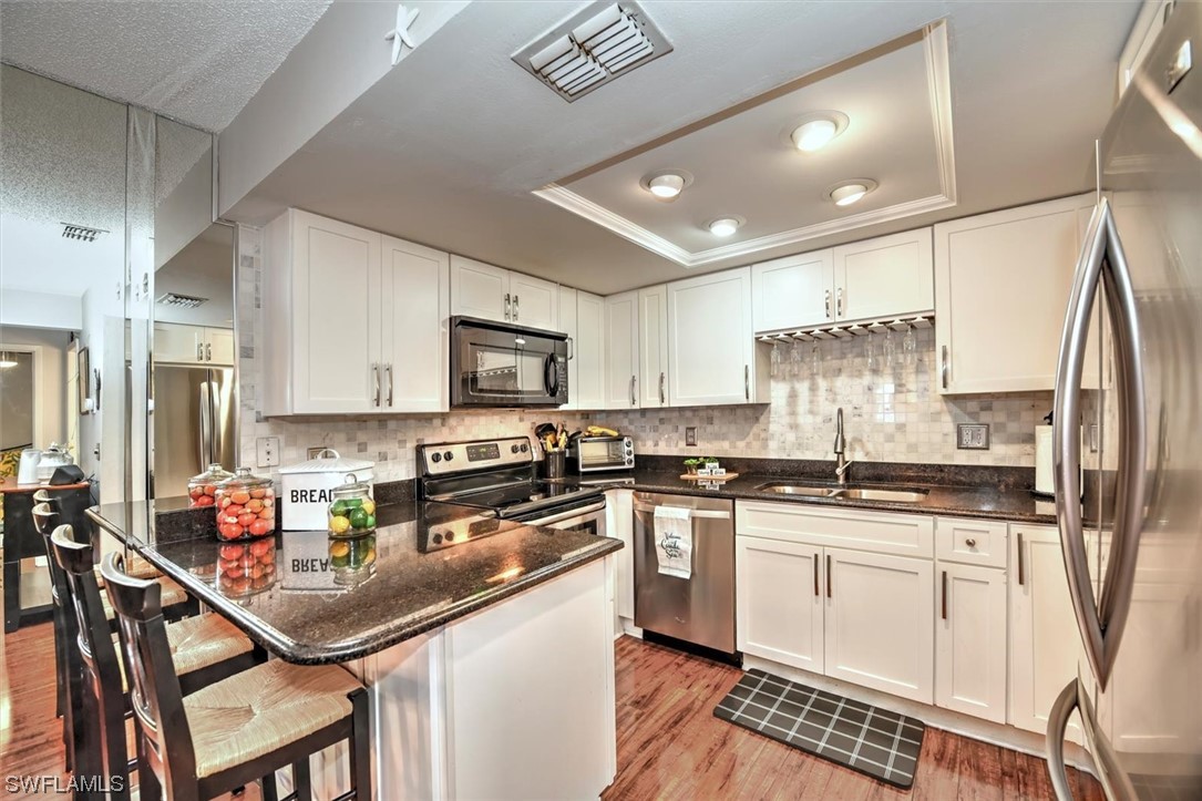 13260 Broadhurst Loop Fort Myers, FL 33919 - Photo 11 of 25 a kitchen with stainless steel appliances granite countertop a sink a stove a refrigerator cabinets and a dining table