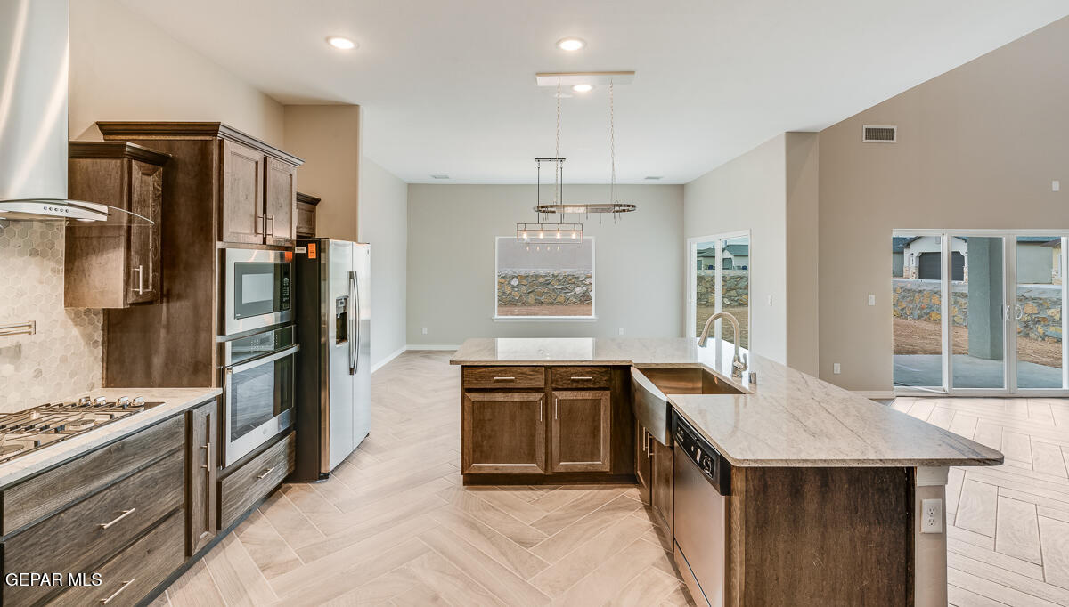 12432 Fill Ball El Paso, TX 79928 - Photo 11 of 37 a kitchen with stainless steel appliances granite countertop a stove a refrigerator and a sink