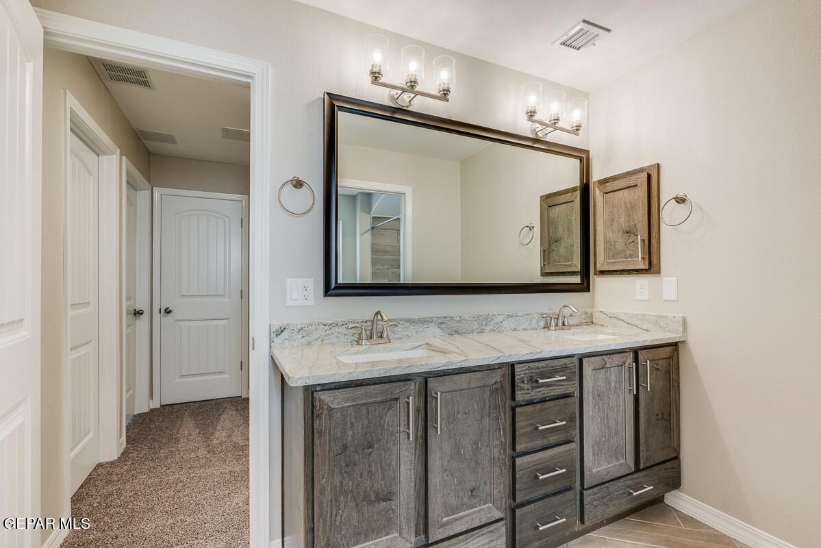 12432 Fill Ball El Paso, TX 79928 - Photo 22 of 37 a en suite bathroom with a double vanity sink and a mirror
