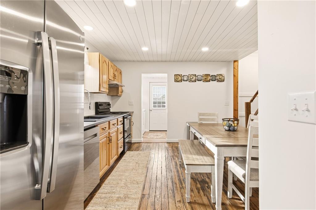 38 3rd Street Cairnbrook, PA 15924 - Photo 9 of 29 a kitchen with stainless steel appliances granite countertop a refrigerator a stove and a sink with wooden floor