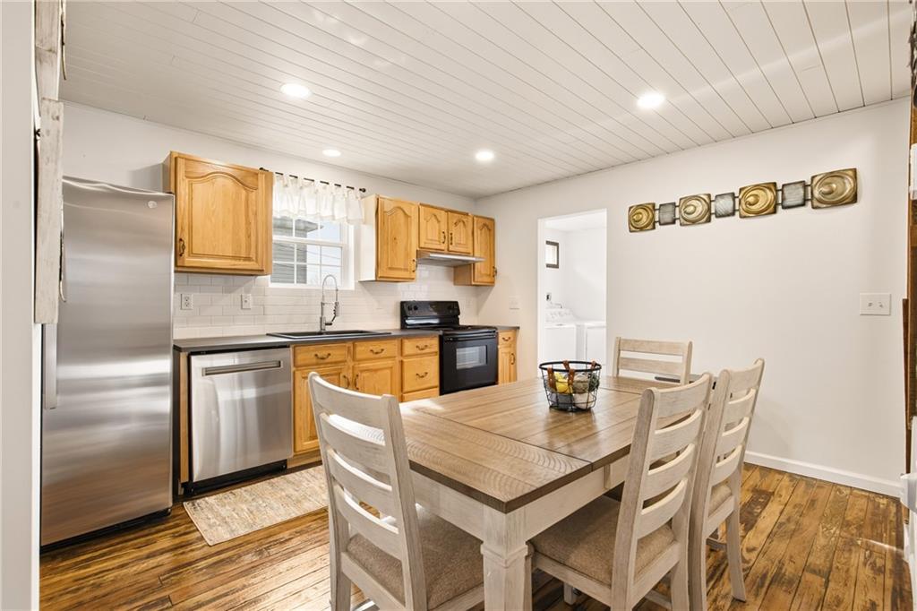 38 3rd Street Cairnbrook, PA 15924 - Photo 10 of 29 a kitchen with a refrigerator a stove a sink dishwasher with a dining table and chair