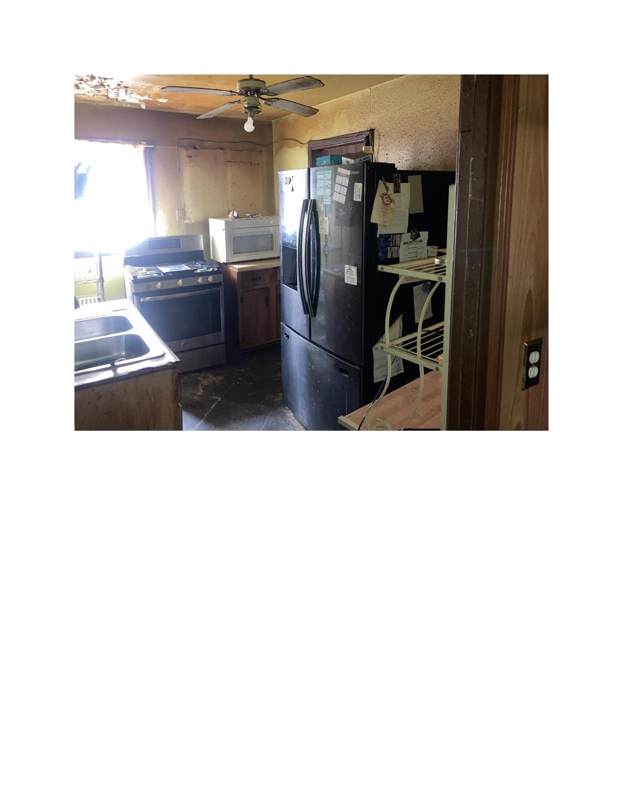 3063 Calvert Avenue Memphis, TN 38108 - Photo 12 of 18 Kitchen featuring stainless steel range with gas stovetop, black refrigerator with ice dispenser, white microwave, and a ceiling fan