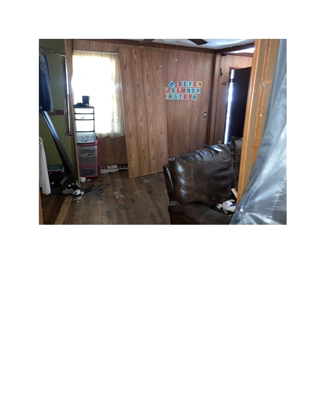 3063 Calvert Avenue Memphis, TN 38108 - Photo 6 of 18 Living area with dark wood finished floors and wooden walls