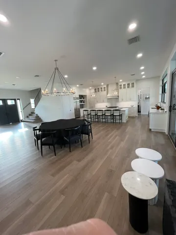 a living room with furniture and a dining table with wooden floor