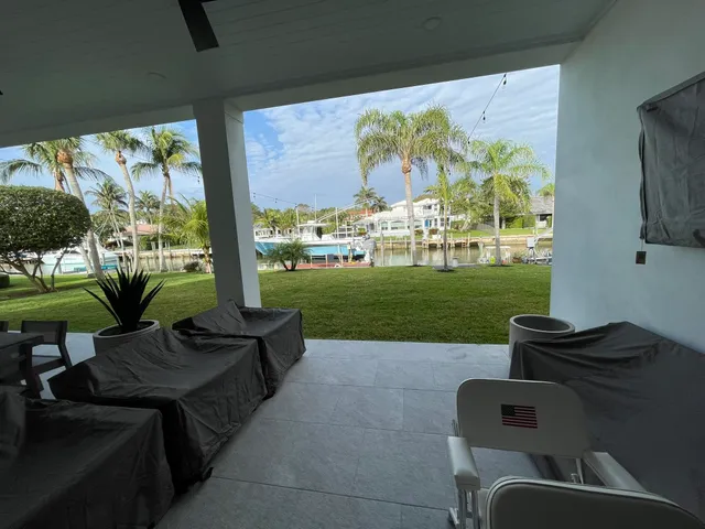 a living room with patio furniture and a floor to ceiling window