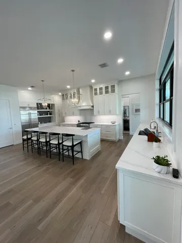 a kitchen with a dining table chairs and white appliances
