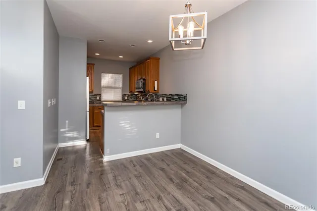 a view of a kitchen with wooden floor and a window