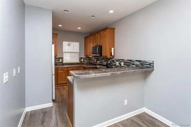 a kitchen with stainless steel appliances granite countertop a sink stove and cabinets