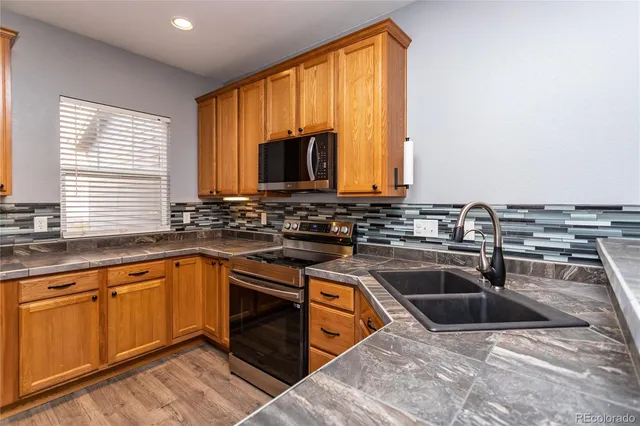 a kitchen with granite countertop a sink and a stove top oven