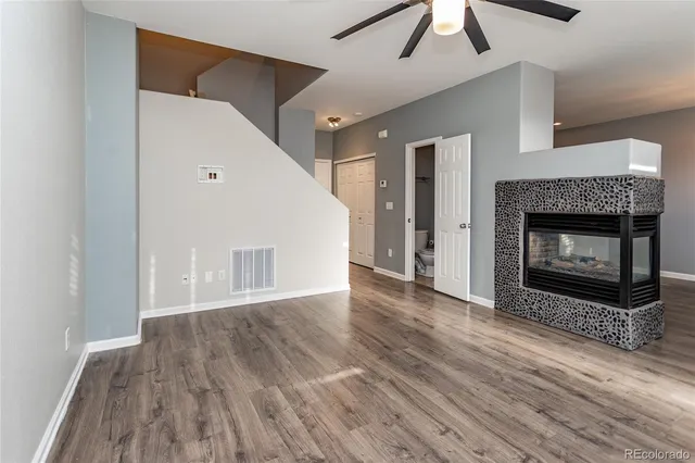 a view of a livingroom with wooden floor and a fireplace