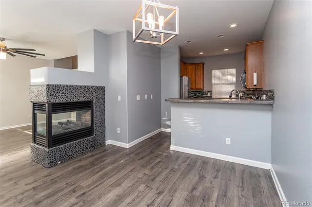 a kitchen with a wooden floor and a fireplace