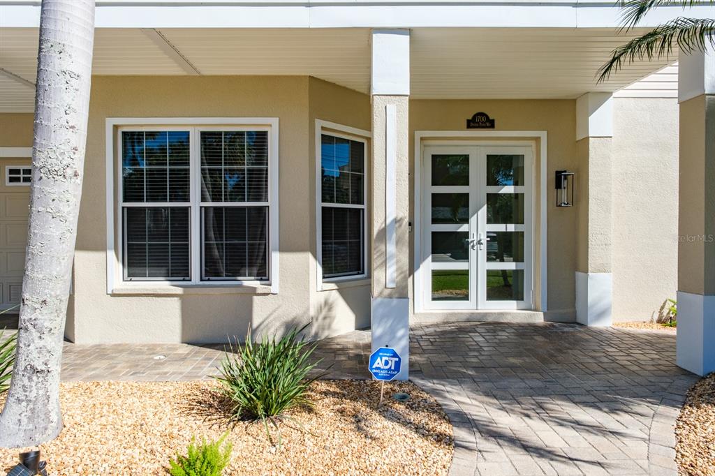 1700 Oyster Point Way Palm Harbor, FL 34683 - Photo 11 of 88 a front view of a house with a window and potted plants