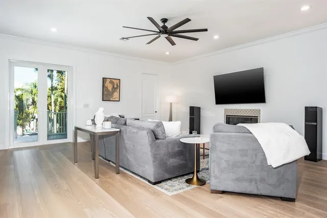 a kitchen with stainless steel appliances kitchen island granite countertop a refrigerator a sink dishwasher a oven with white cabinets and wooden floor