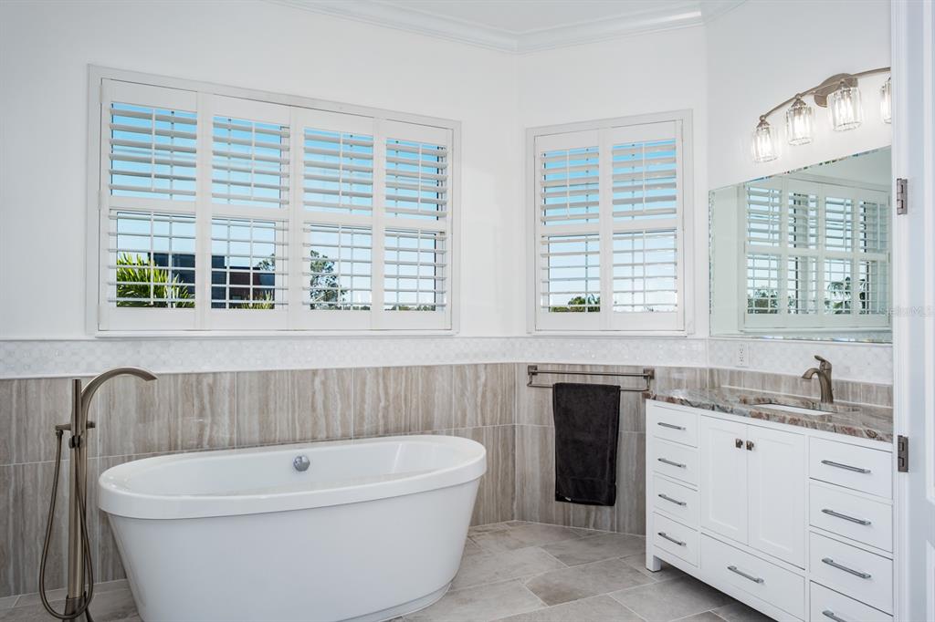 1700 Oyster Point Way Palm Harbor, FL 34683 - Photo 38 of 88 a bathroom with a double vanity sink a bathtub and window