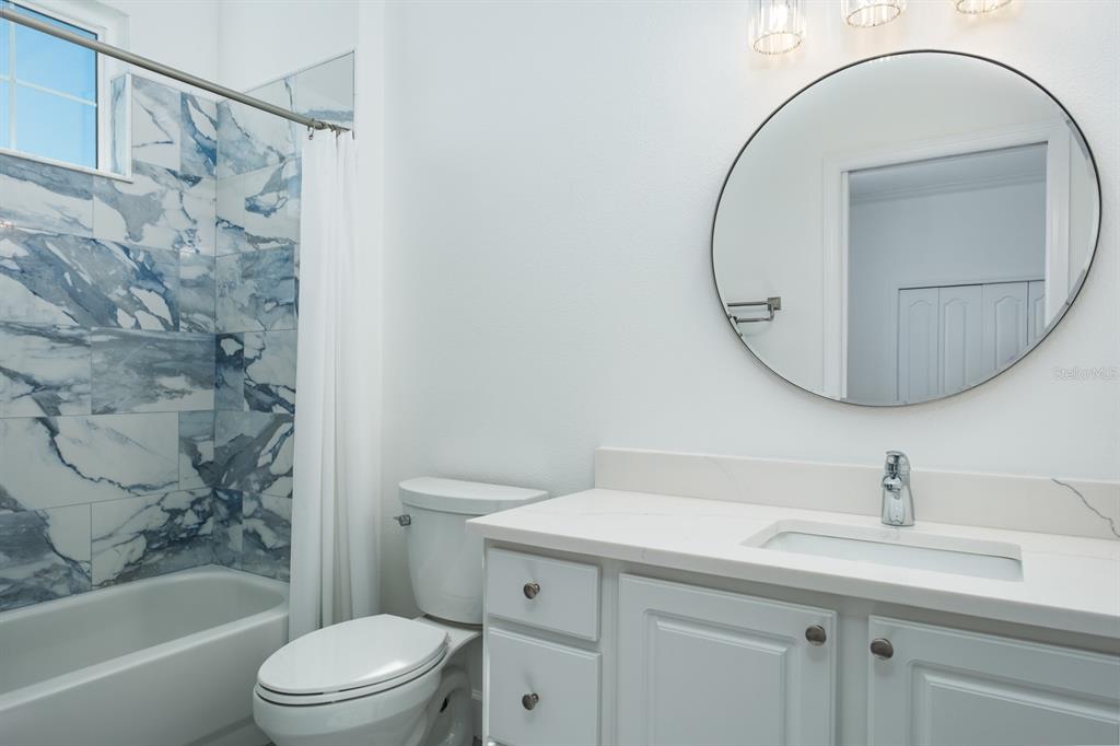1700 Oyster Point Way Palm Harbor, FL 34683 - Photo 45 of 88 a bathroom with a sink a toilet and a mirror