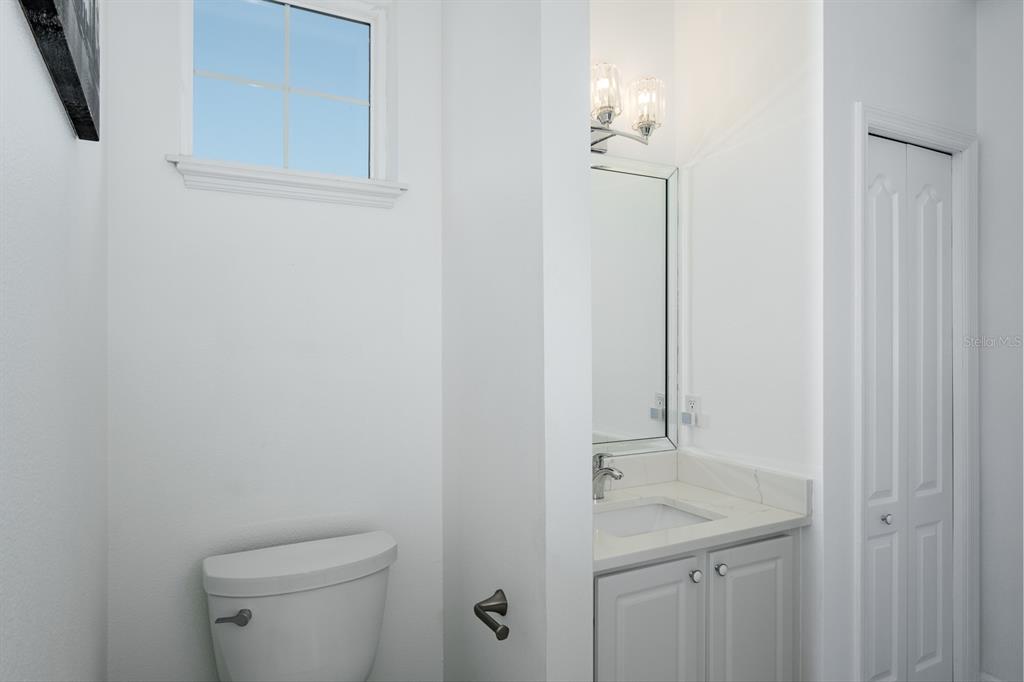 1700 Oyster Point Way Palm Harbor, FL 34683 - Photo 52 of 88 a bathroom with a granite countertop sink a toilet and with mirror