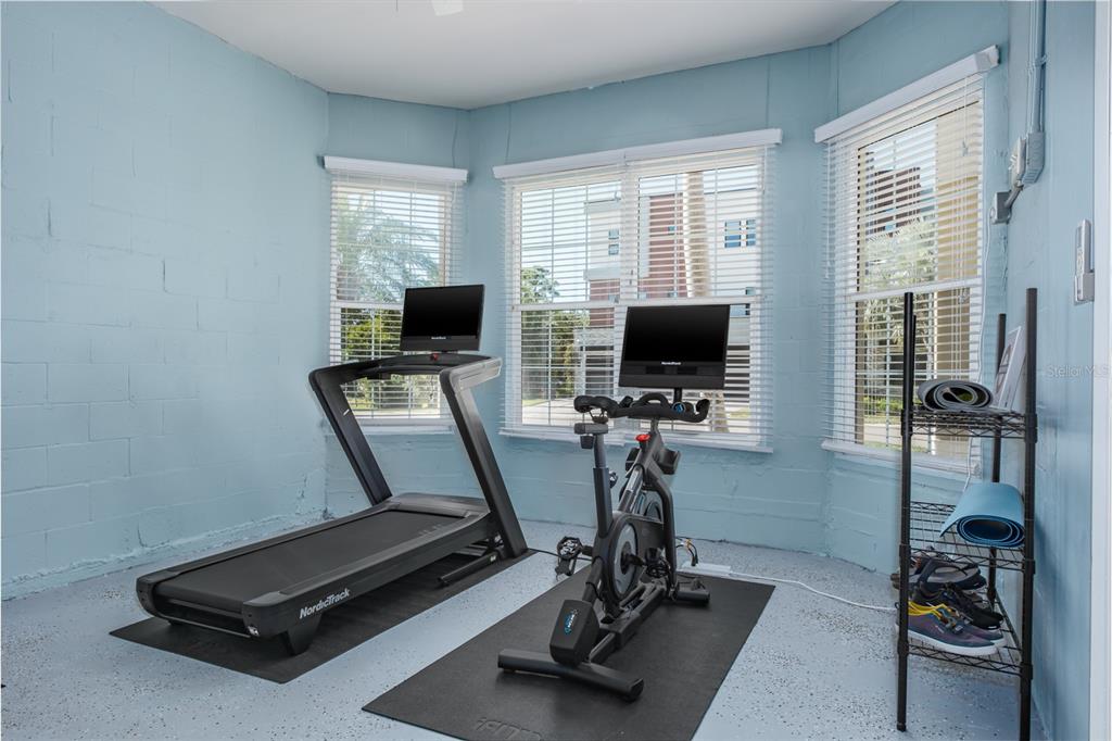 1700 Oyster Point Way Palm Harbor, FL 34683 - Photo 54 of 88 a room with gym equipment and a flat screen tv