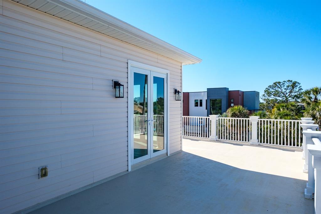 1700 Oyster Point Way Palm Harbor, FL 34683 - Photo 70 of 88 a view of a porch with wooden floor and fence