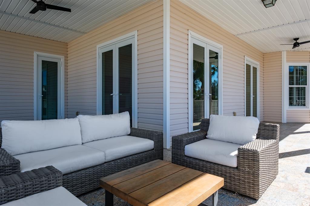 1700 Oyster Point Way Palm Harbor, FL 34683 - Photo 76 of 88 a view of a patio with couches and a dining table and chairs with wooden floor