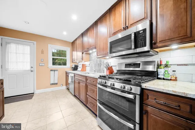 a kitchen with stainless steel appliances granite countertop a stove a sink and a microwave