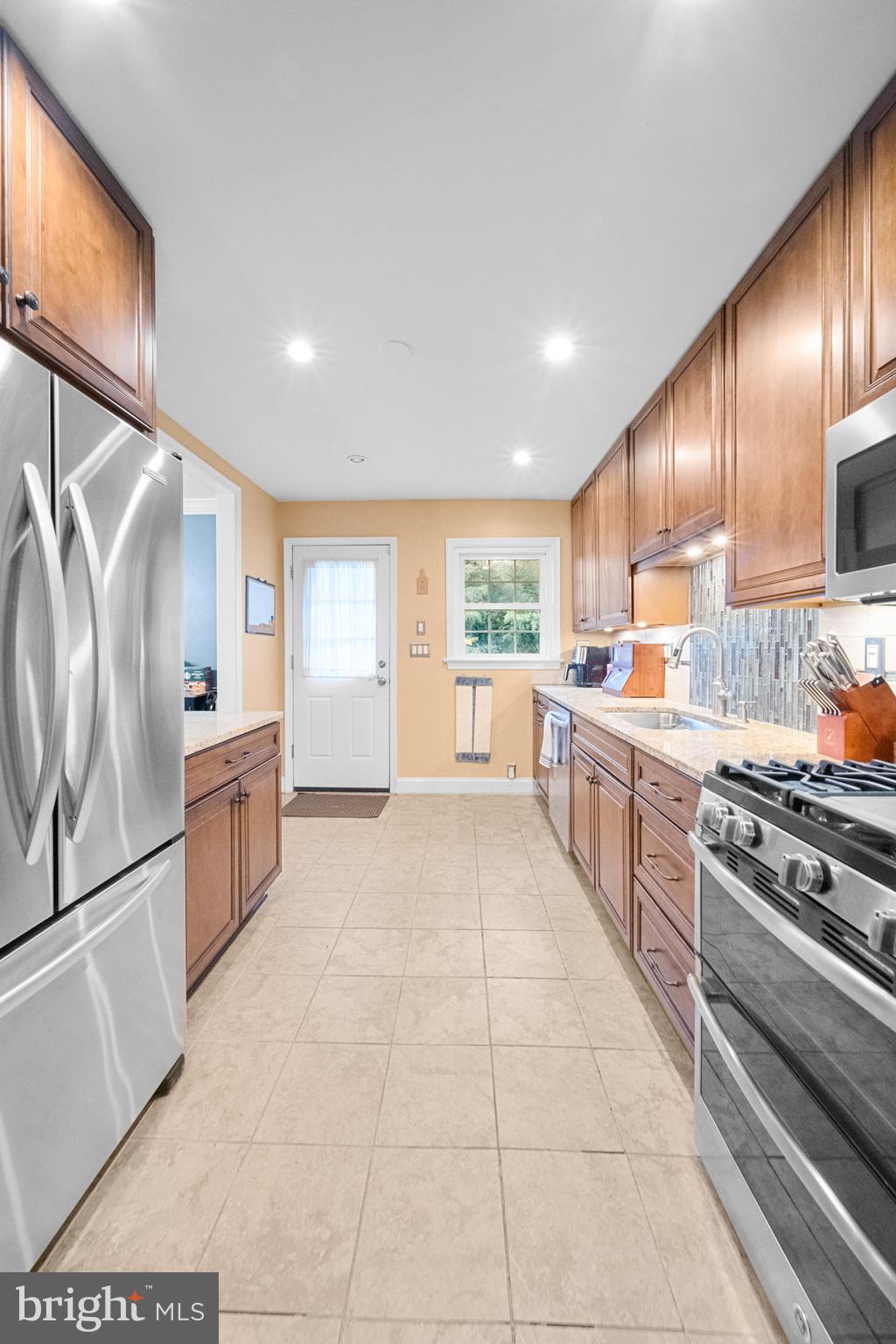 10600 Springmann Drive Fairfax, VA 22030 - Photo 10 of 78 a large kitchen with stainless steel appliances granite countertop a stove a sink and a refrigerator