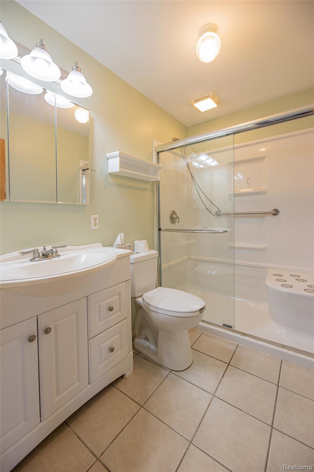 2855 Farmers Creek Road Metamora, MI 48455 - Photo 37 of 51 Bathroom featuring a white vanity with integrated sink, a toilet, and a walk-in shower with glass enclosure and built-in bench