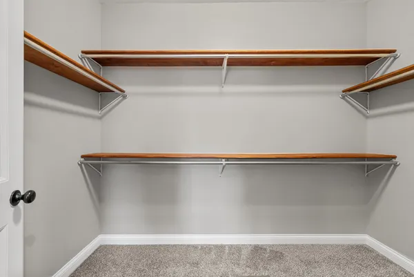 an empty room with windows and chandelier fan