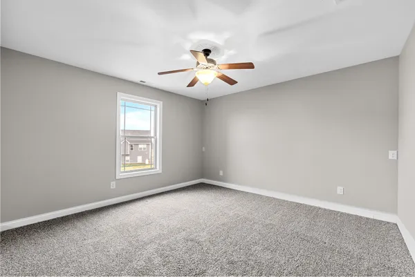 a view of an empty room with a ceiling fan