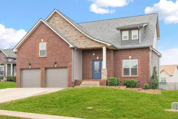 a view of brick house with a small yard