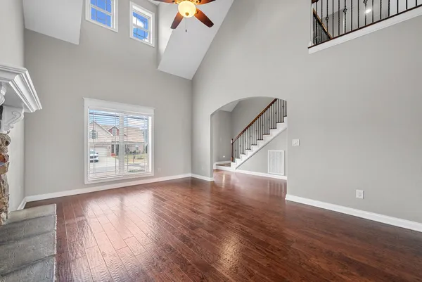 a view of a hallway with wooden floor and a chandelier