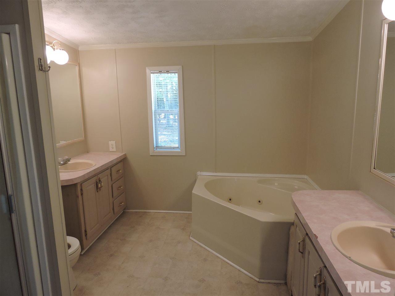 225 Bowling Road Roxboro, NC 27574 - Photo 6 of 19 a bathroom with a tub sink and mirror