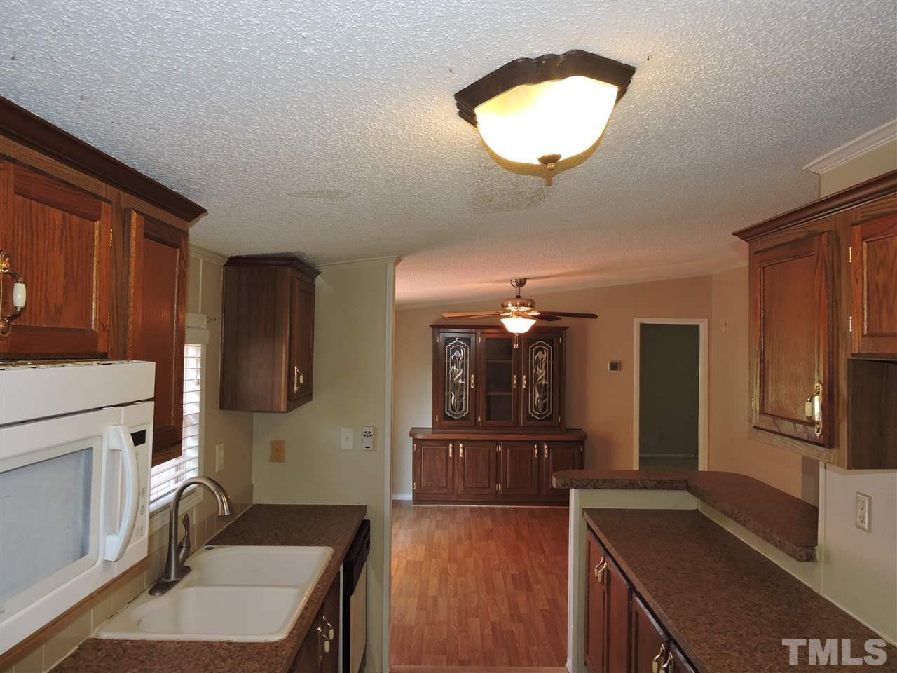 225 Bowling Road Roxboro, NC 27574 - Photo 8 of 19 a kitchen with a refrigerator and a stove top oven