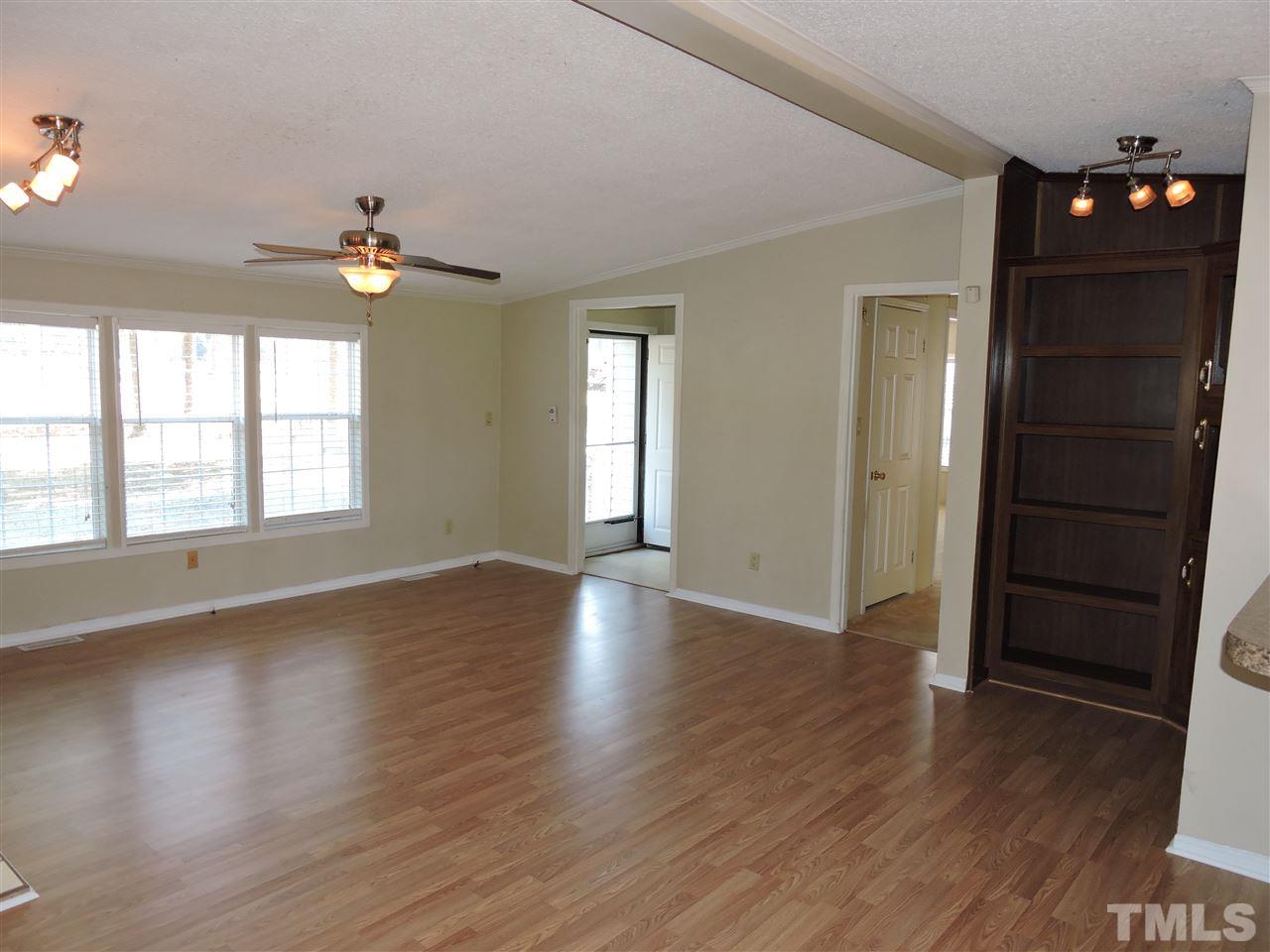 225 Bowling Road Roxboro, NC 27574 - Photo 9 of 19 an empty room with wooden floor and windows