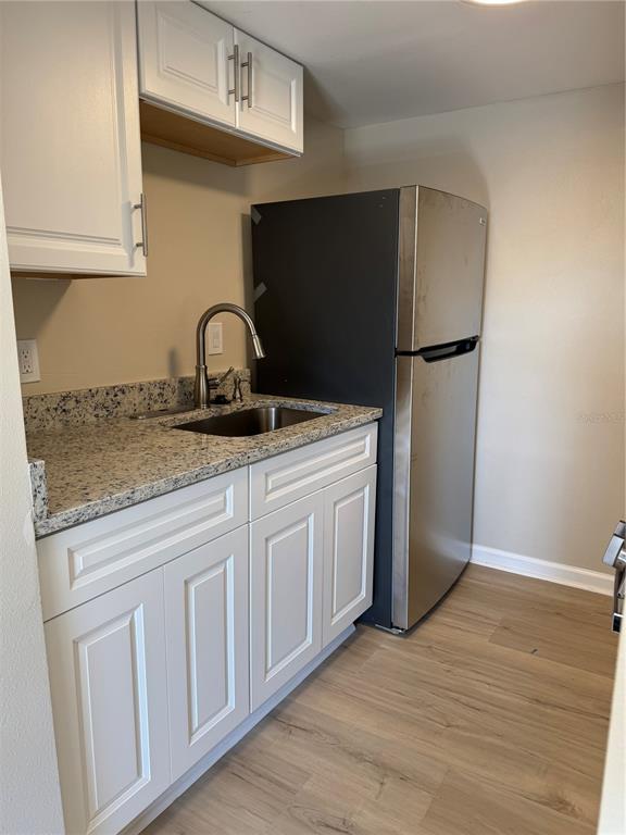 5521 Bay Boulevard, Unit 105 Port Richey, FL 34668 - Photo 4 of 15 a kitchen with appliances a sink and cabinets