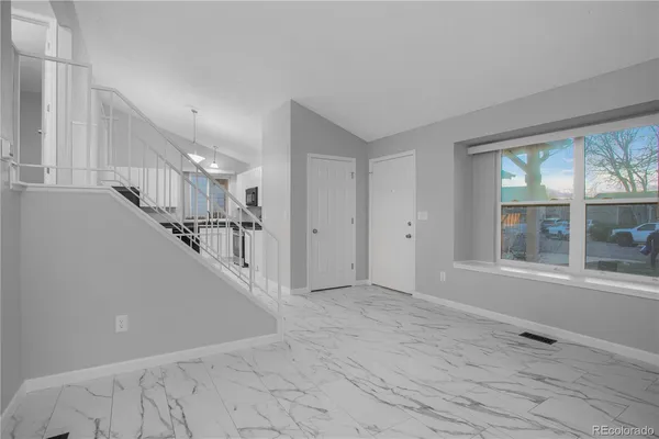 a view of entryway and hall with wooden floor