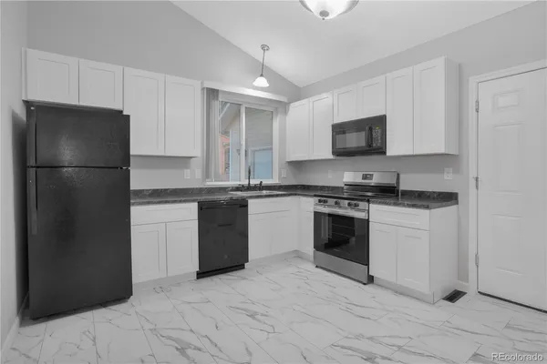 a kitchen with granite countertop a sink a stove and microwave